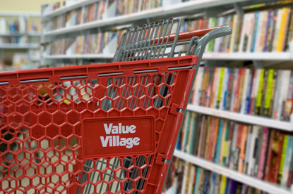 Value Village shopping cart in the book aisle.