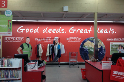 Cashier at the register in front of a red wall with the message 